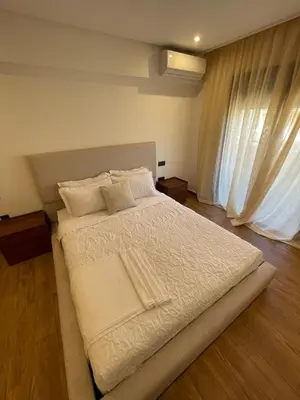 a bedroom with a bed with white sheets and a window at Palmeraie Appart B4 Piscine & Parking in Marrakech