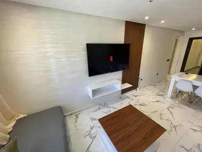 a living room with a flat screen tv on a wall at Luxury 2BR Pool Apartement Marrakech in Marrakech