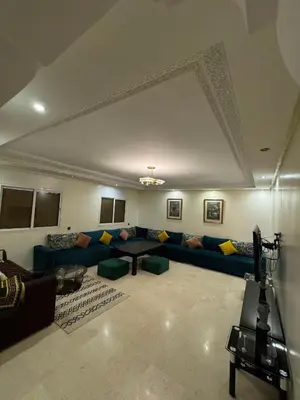 a living room with a blue couch and a table at Appartement près de la gare de Marrakech in Marrakech