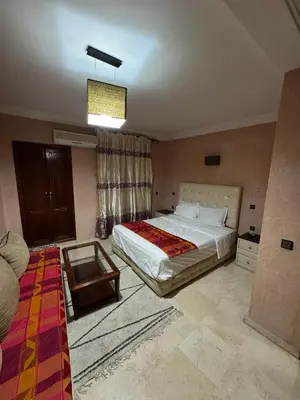 a bedroom with a large bed and a table at Appartement près de la gare de Marrakech in Marrakech