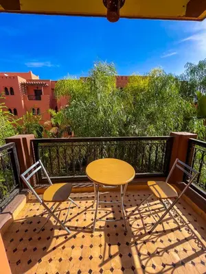 a patio with a table and chairs on a balcony at Stunning Patios & Gardens Apartment in Marrakech