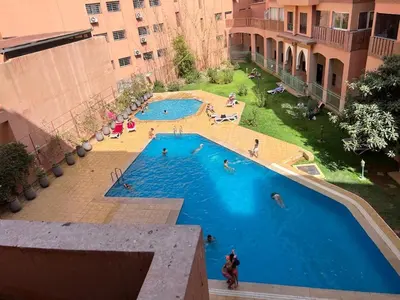 an overhead view of a large swimming pool with people in it at Résidence SOFIA PALMERAIE in Marrakech