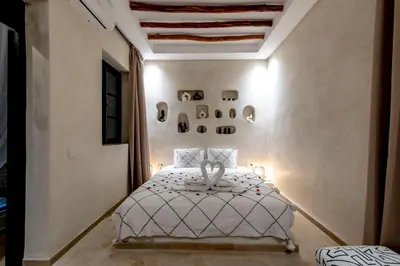 a bedroom with a white bed in a room at Riad Dar Yousra in Marrakech