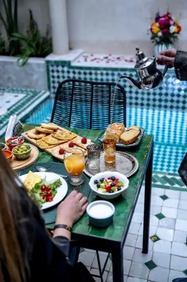a table with plates of food and drinks on it at Riad Dar Yousra in Marrakech