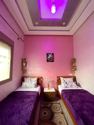 two beds in a room with a purple ceiling at Mima in Marrakech