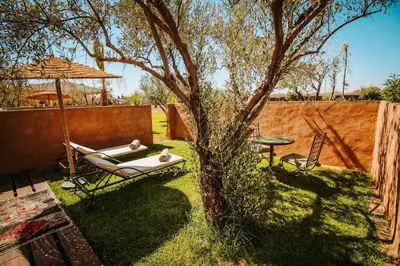 a yard with a hammock and a tree and a table at Hotel & Spa La Ferme El Dar in Marrakech