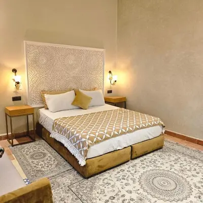 a bedroom with a large bed with two night stands at Maison de vacances avec piscine in Marrakech