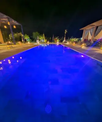 a swimming pool at night with blue illumination at Maison de vacances avec piscine in Marrakech