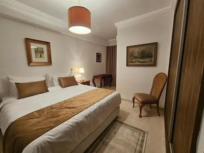 a hotel room with a large bed and a chair at Studio Central Nour in Marrakech