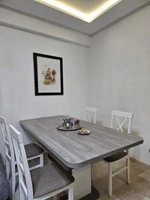 a dining room with a table and white chairs at Studio Central Nour in Marrakech