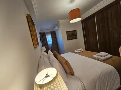 a bedroom with a large white bed and a table at Studio Central Nour in Marrakech
