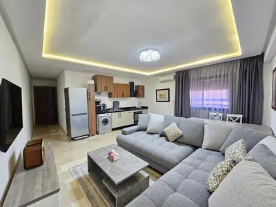 a living room with a couch and a kitchen at Studio Central Nour in Marrakech