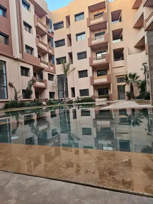 an empty swimming pool in front of a building at Studio Central Nour in Marrakech