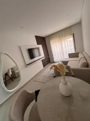 a living room with a table and a mirror at Logement F2 neuf Gueliz Gare in Marrakech