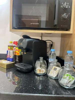 a kitchen counter with a coffee maker and bottles of food at Logement F2 neuf Gueliz Gare in Marrakech