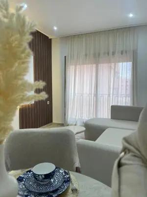 a living room with a table and chairs and a window at Logement F2 neuf Gueliz Gare in Marrakech