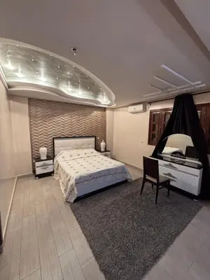 a bedroom with a bed and a chair and a piano at Villa Saber in Marrakech