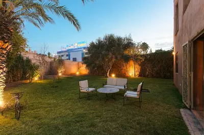 a patio with a table and chairs in a yard at Your Traditional Marrakchi Villa in Marrakech