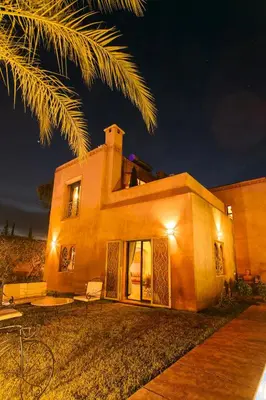 a house with a palm tree in front of it at Your Traditional Marrakchi Villa in Marrakech