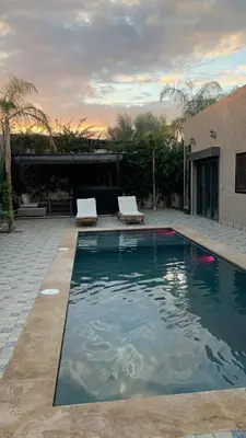 a swimming pool with two chairs and a house at Villa Marrakech in Marrakech