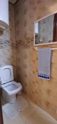 a bathroom with a toilet and a mirror and a towel at Résidence Hamza - Appartement familial in Marrakech