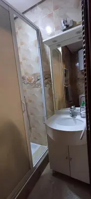 a bathroom with a sink and a shower with a mirror at Résidence Hamza - Appartement familial in Marrakech
