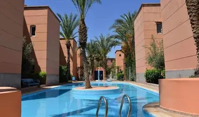 a swimming pool with palm trees in a resort at Said MM in Marrakech