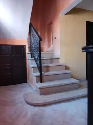 a staircase in a house with a wooden door at Said MM in Marrakech
