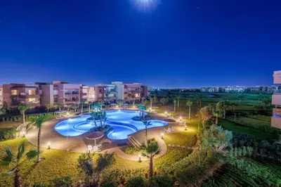 an overhead view of a large swimming pool at night at Appartement prestigia golf accès piscine in Marrakech