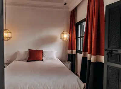 a bedroom with a white bed with two lamps at Riad Beltza - 