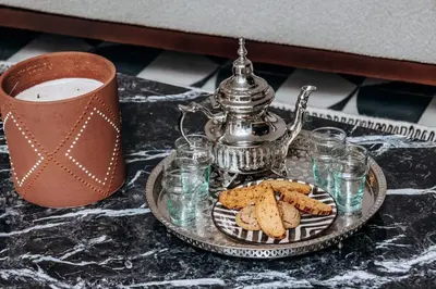 a tea pot and cookies on a tray with a cup of coffee at Riad Beltza - 