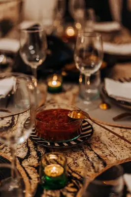 a table with wine glasses and a bowl of food at Riad Beltza - 