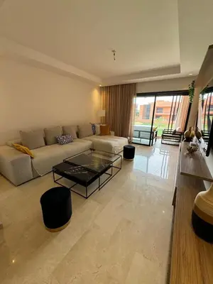 a living room with a couch and a table at Domaine de Noria Isli 2 - Magnifique 2 chambres - Vue directe sur la piscine in Marrakech