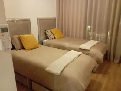 two beds in a hotel room with yellow pillows at Domaine de Noria Isli 2 - Magnifique 2 chambres - Vue directe sur la piscine in Marrakech