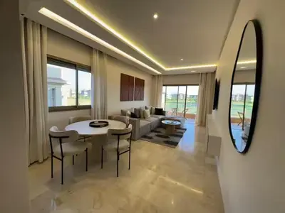 a living room with a table and chairs and a couch at Apparemment haute standing golf prestigia in Marrakech