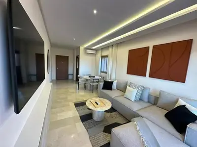 a living room with a couch and a table at Apparemment haute standing golf prestigia in Marrakech