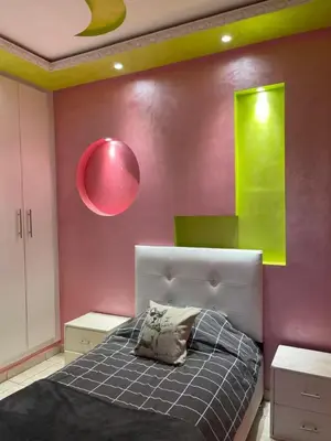 a bedroom with a bed and a pink wall at Appartement à louer Marrakech tous les services in Marrakech