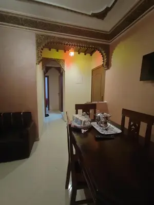 a dining room with a wooden table and chairs at dyour marjan saada in Marrakech
