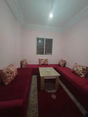 a living room with a red couch and a table at dyour marjan saada in Marrakech