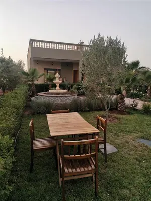 a wooden table and chairs in front of a house at Villa Zaina in Marrakech
