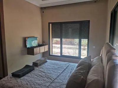 a bedroom with a bed and a large window at Villa Zaina in Marrakech