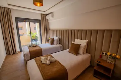 a hotel room with two beds and a window at Golden Palm Resort in Marrakech