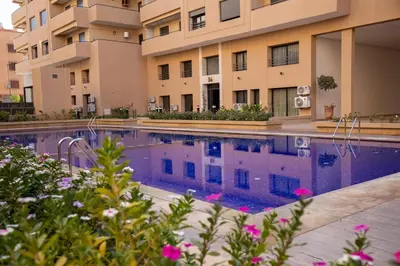 a swimming pool in front of a building at Golden Palm Resort in Marrakech