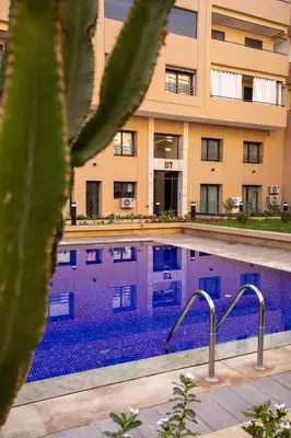 a swimming pool in front of a building at Golden Palm Resort in Marrakech