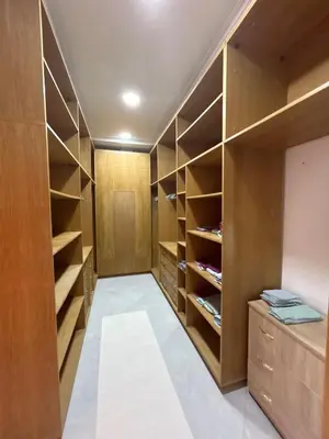 a walk in closet with wooden cabinets and shelves at villa Marrakesh in Marrakech