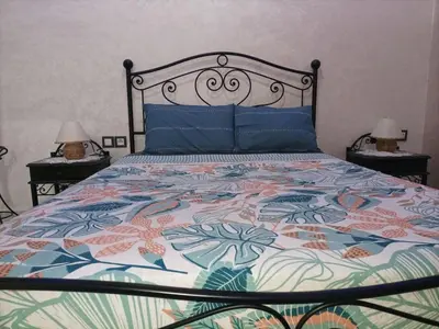 a bedroom with a bed with a colorful quilt at MARRAKECh TYPICAL & CONFORT APPARTEMENT in Marrakech