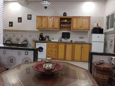 a kitchen with wooden cabinets and a table at MARRAKECh TYPICAL & CONFORT APPARTEMENT in Marrakech