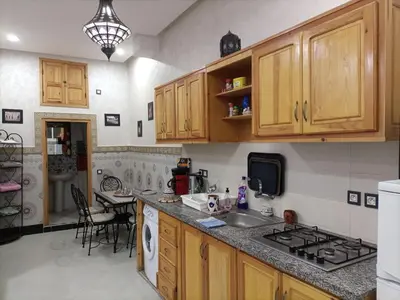 a kitchen with wooden cabinets and a sink and a stove at MARRAKECh TYPICAL & CONFORT APPARTEMENT in Marrakech