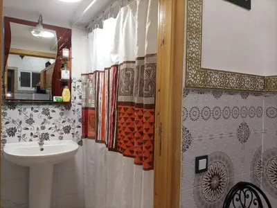 a bathroom with a sink and a toilet and a mirror at MARRAKECh TYPICAL & CONFORT APPARTEMENT in Marrakech
