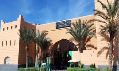 a building with palm trees in front of it at MARRAKECh TYPICAL & CONFORT APPARTEMENT in Marrakech